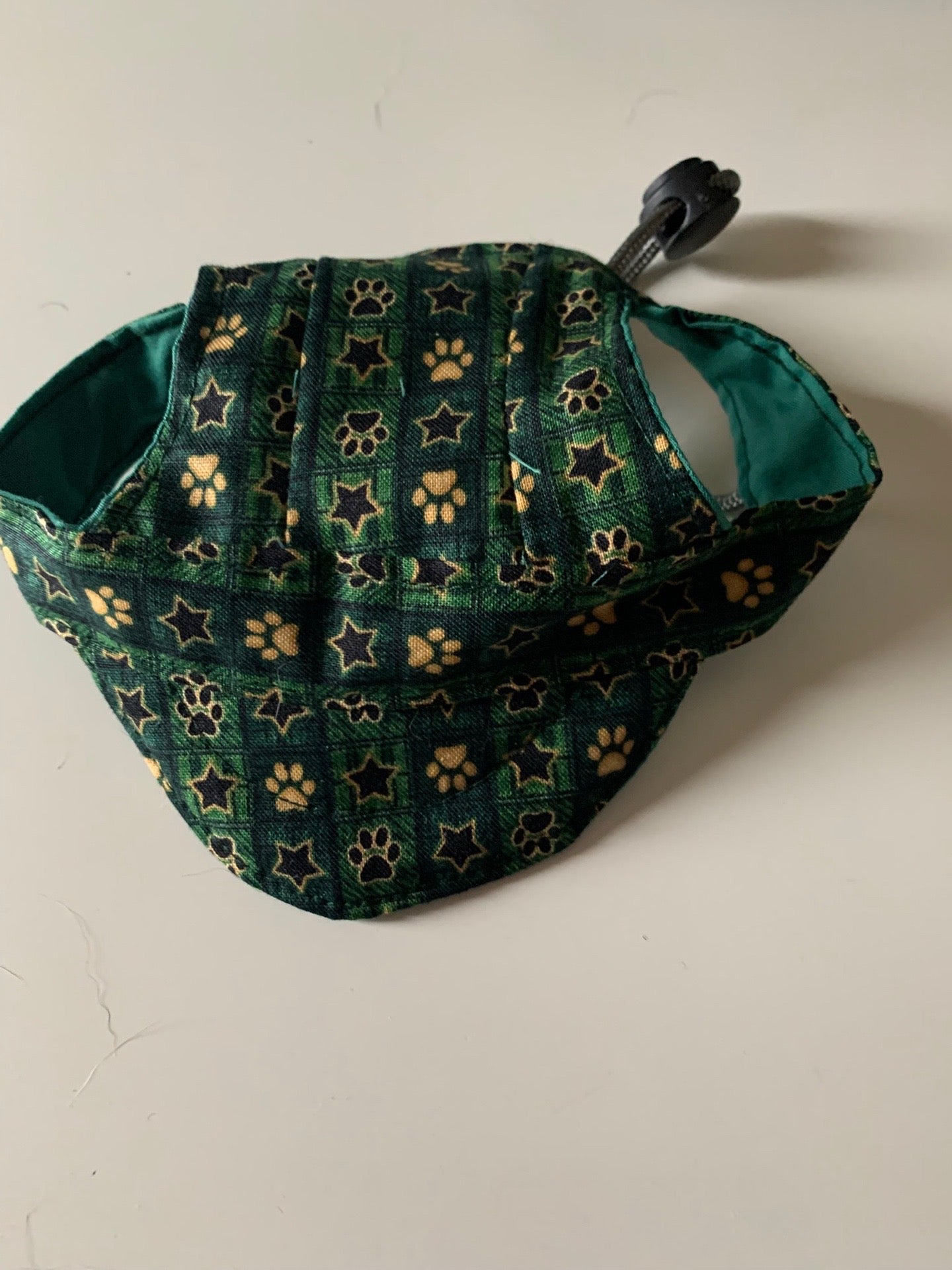 Paw prints and stars on green pet hats