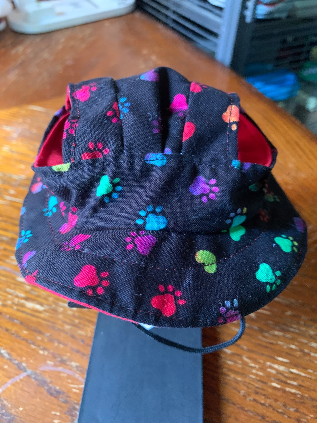 Multicolored paw prints on black pet bucket hat